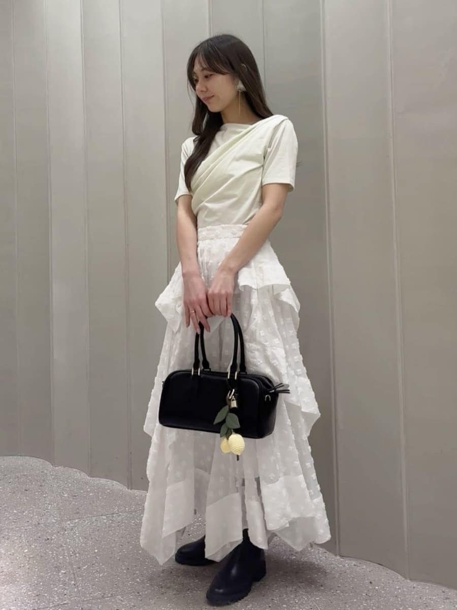 その他のスカート、グリーン系のTシャツ/カットソー、ブラック系のボストンバッグを着用したレディースの春コーディネートの2枚目の写真