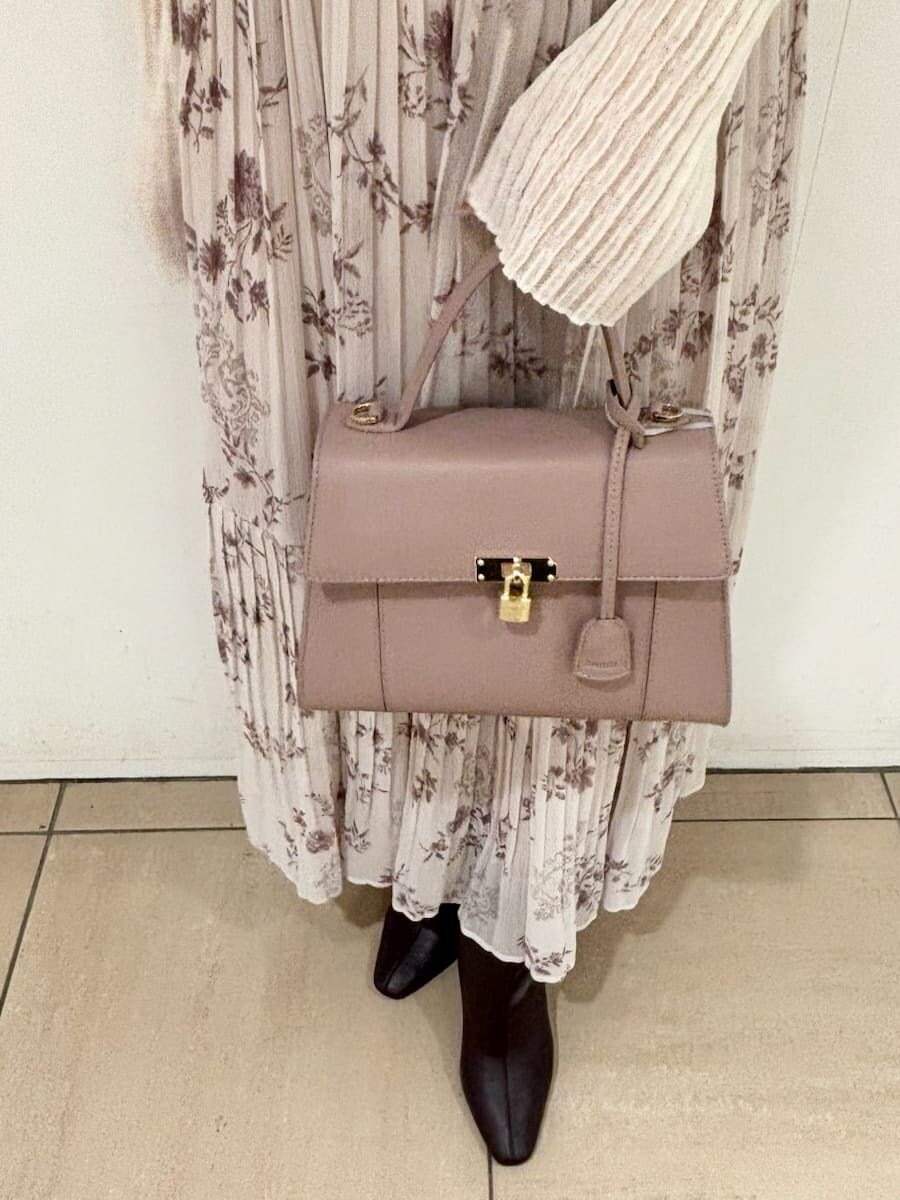 ピンク系のワンピース、ホワイト系のカーディガン/ボレロ、ピンク系のハンドバッグを着用したレディースの秋コーディネートの6枚目の写真