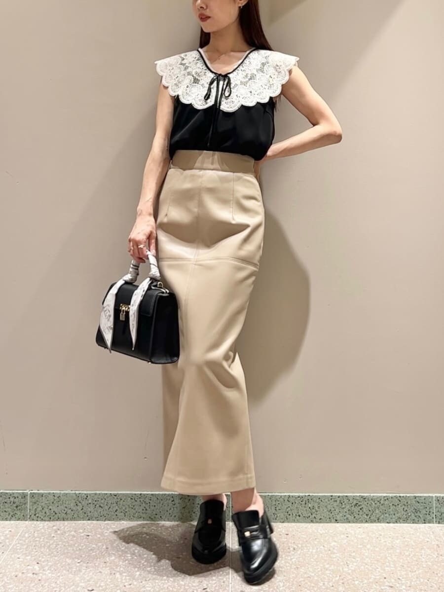 ブラック系のシャツ/ブラウス、ホワイト系のスカート、ブラック系のハンドバッグを着用したレディースの夏コーディネートの4枚目の写真