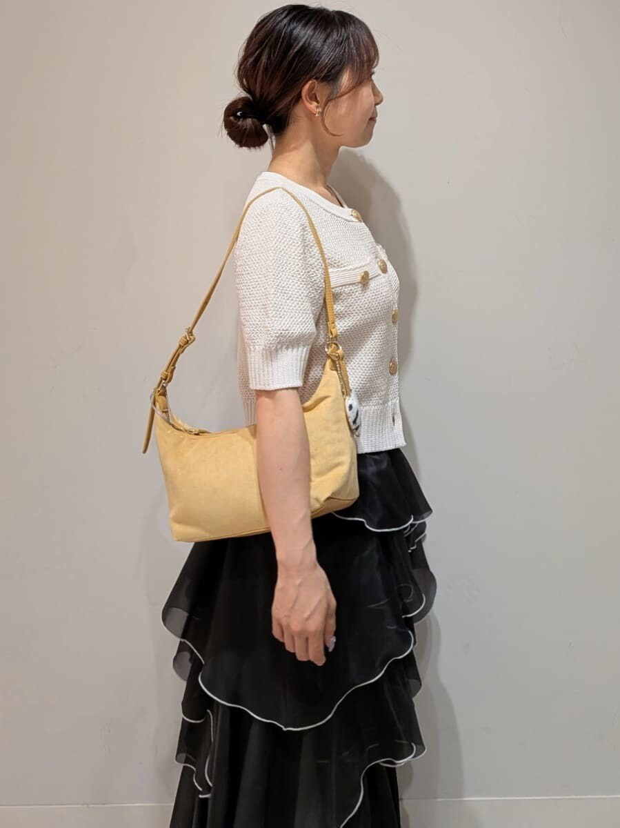 ブラック系のスカート、ホワイト系のカーディガン/ボレロ、イエロー系のショルダーバッグを着用したレディースの夏コーディネートの4枚目の写真