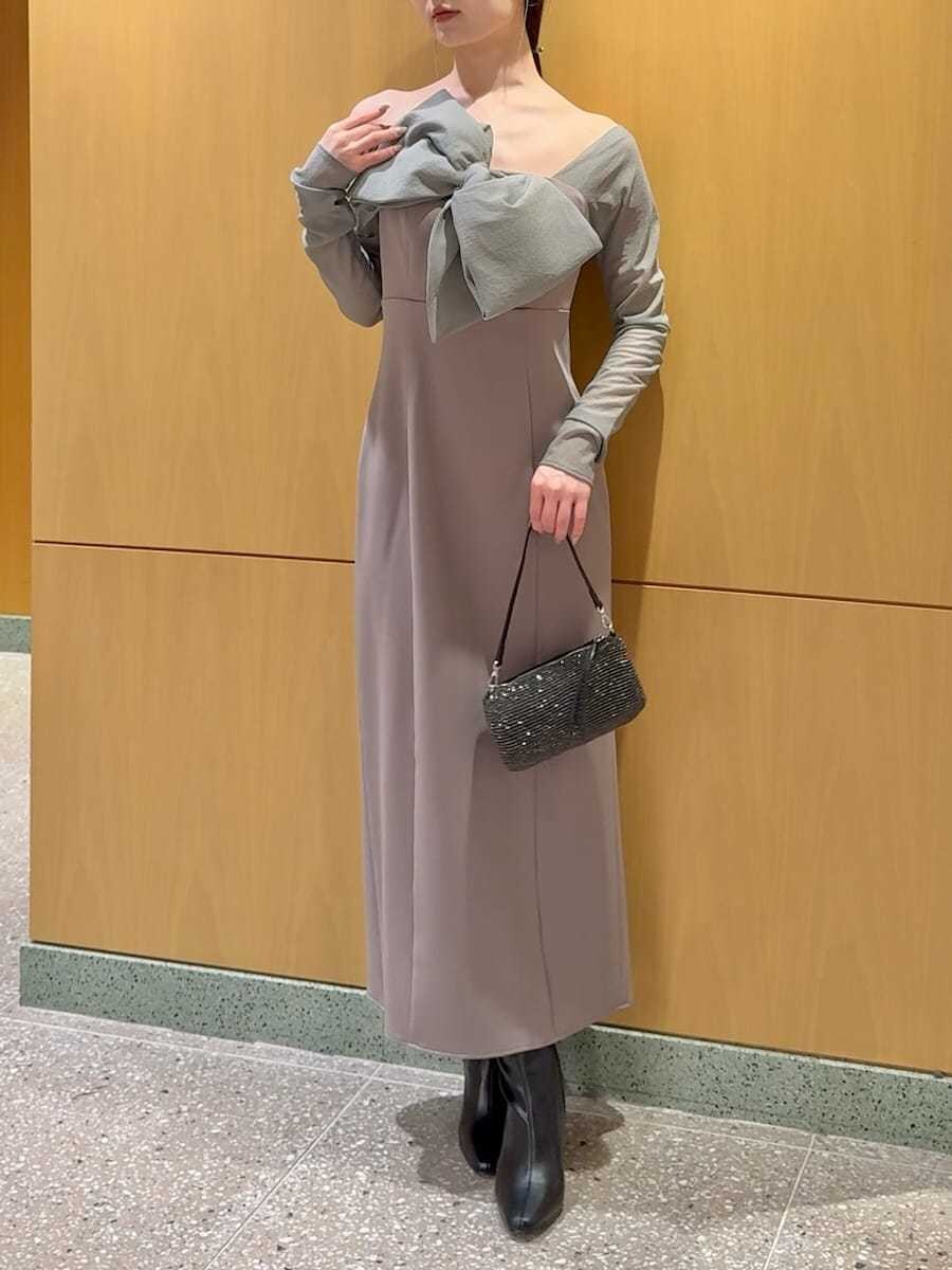 ブラック系のブーツ、ベージュ系のワンピース、シルバー系のイヤリングを着用したレディースの冬コーディネートの7枚目の写真