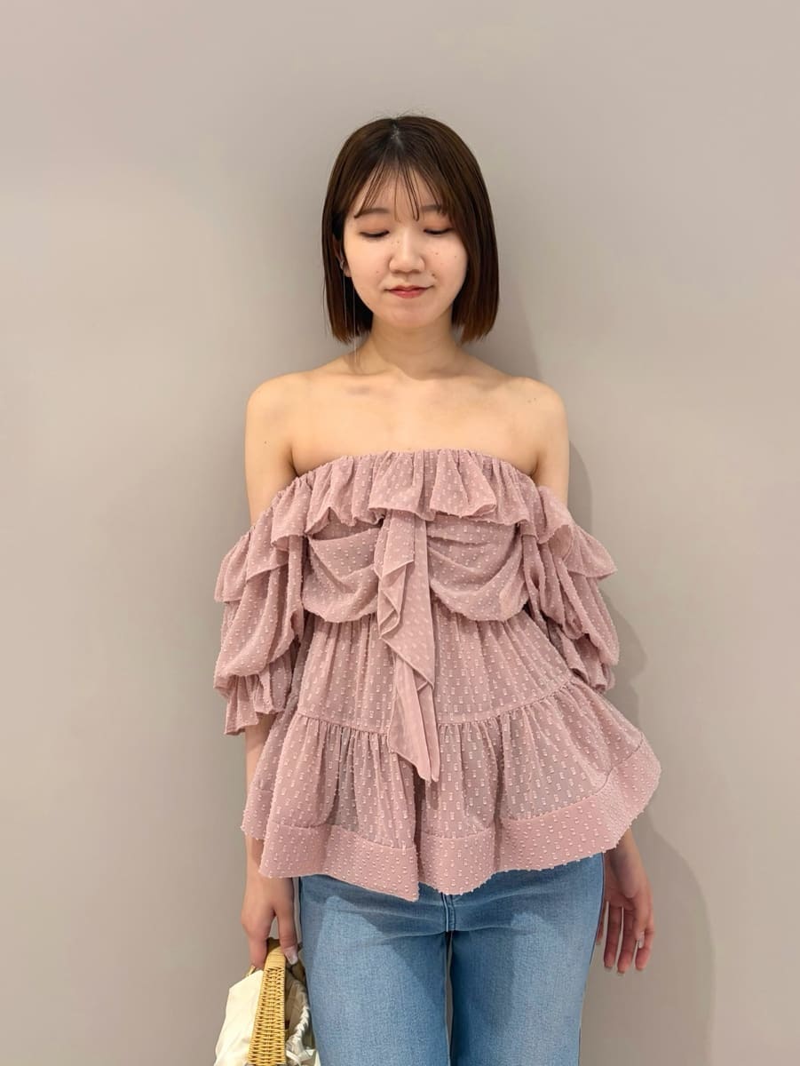 ブルー系のデニムパンツ、ホワイト系のサンダル、ホワイト系のかごバッグを着用したレディースの夏コーディネートの2枚目の写真