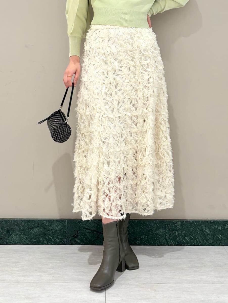 ホワイト系のスカート、グリーン系のニット/セーターを着用したレディースの冬コーディネートの6枚目の写真