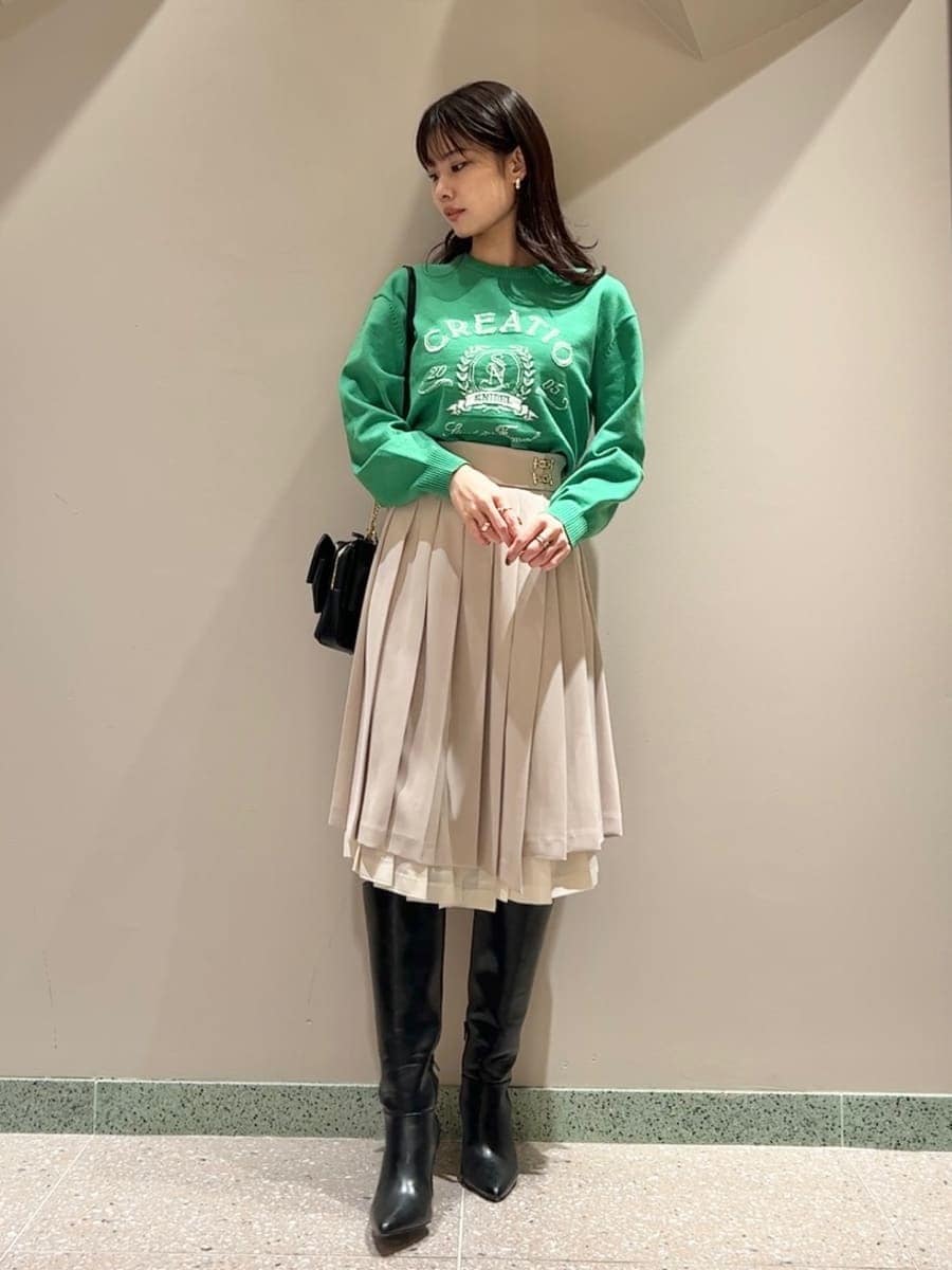 ブラック系のブーツ、ベージュ系のスカート、ブラック系のショルダーバッグを着用したレディースの冬コーディネートの6枚目の写真