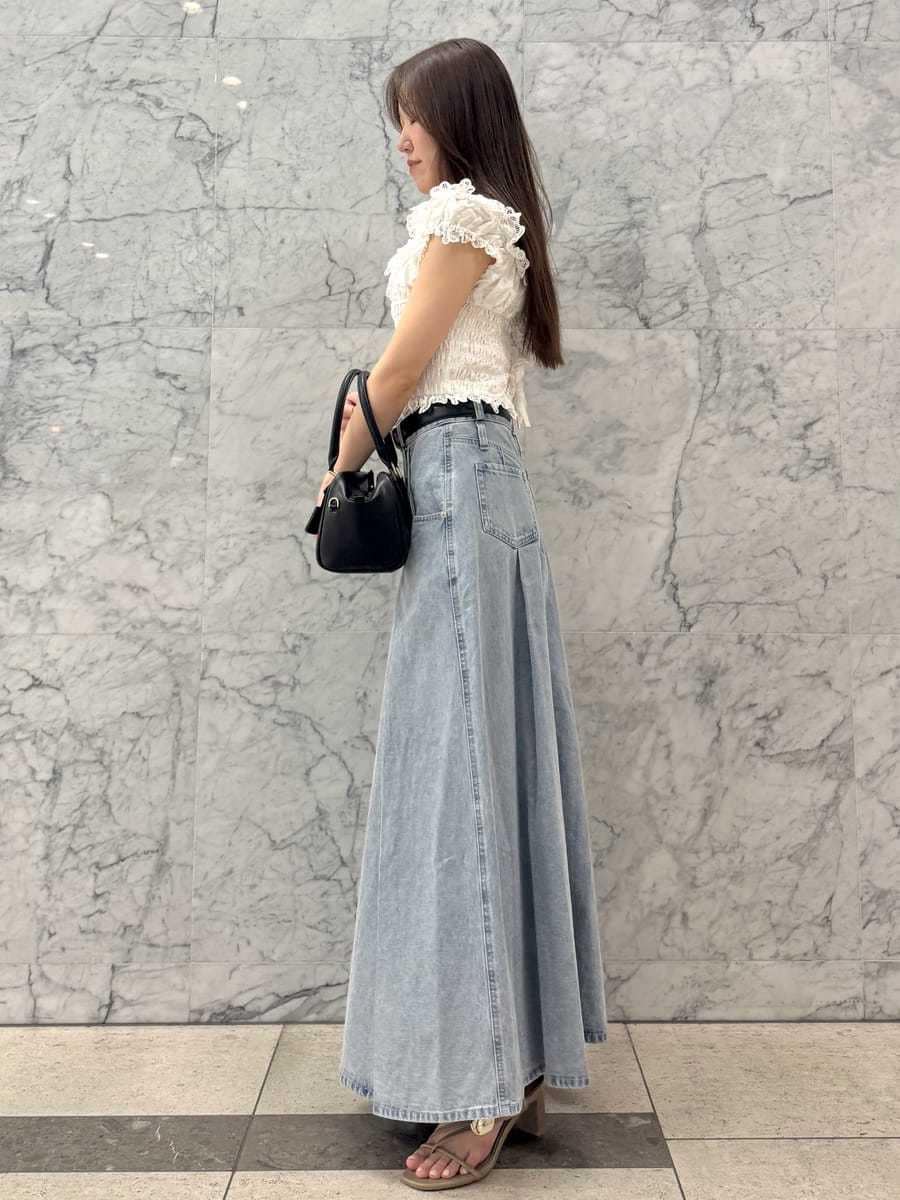 ブルー系のスカート、ホワイト系のシャツ/ブラウス、ブラック系のボストンバッグを着用したレディースの春コーディネートの2枚目の写真