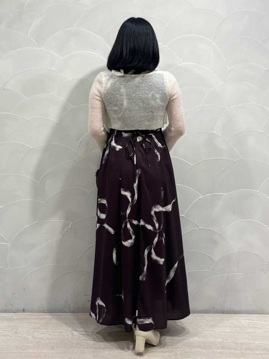 ブラック系のハンドバッグ、ブラウン系のワンピースを着用したレディースの冬コーディネートの3枚目の写真