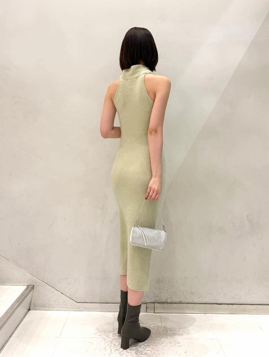 ベージュ系のキャミソール、グリーン系のチェスターコート、グリーン系のワンピースを着用したレディースの冬コーディネートの4枚目の写真