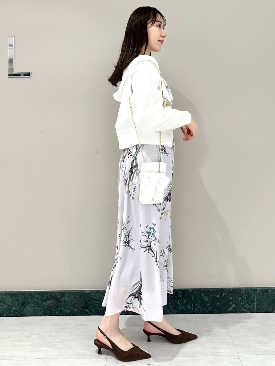 ホワイト系のパーカー、パープル系のワンピース、ブラウン系のパンプスを着用したレディースの冬コーディネートの5枚目の写真