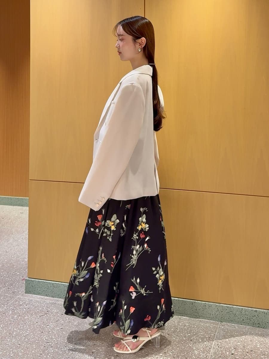 ホワイト系のテーラードジャケット、ブラック系のワンピース、ホワイト系のショルダーバッグを着用したレディースの春コーディネートの3枚目の写真