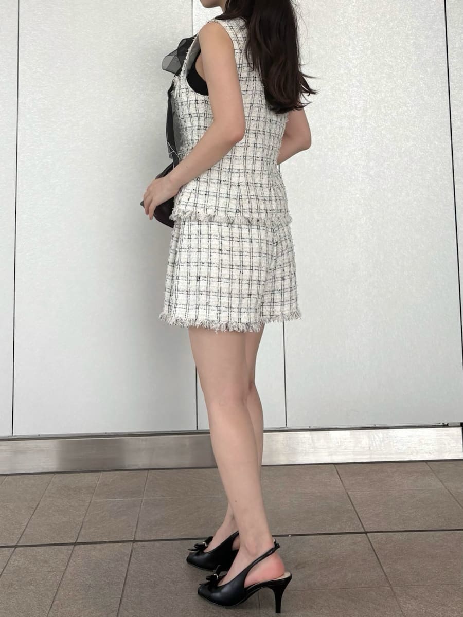 ホワイト系のベスト、ホワイト系のその他パンツ、ブラック系のニット/セーターを着用したレディースの夏コーディネートの4枚目の写真