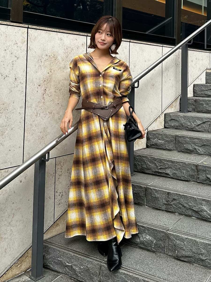 ブラック系のボストンバッグ、ホワイト系のピアス（両耳用）、ブラウン系のベルトを着用したレディースの冬コーディネートの3枚目の写真