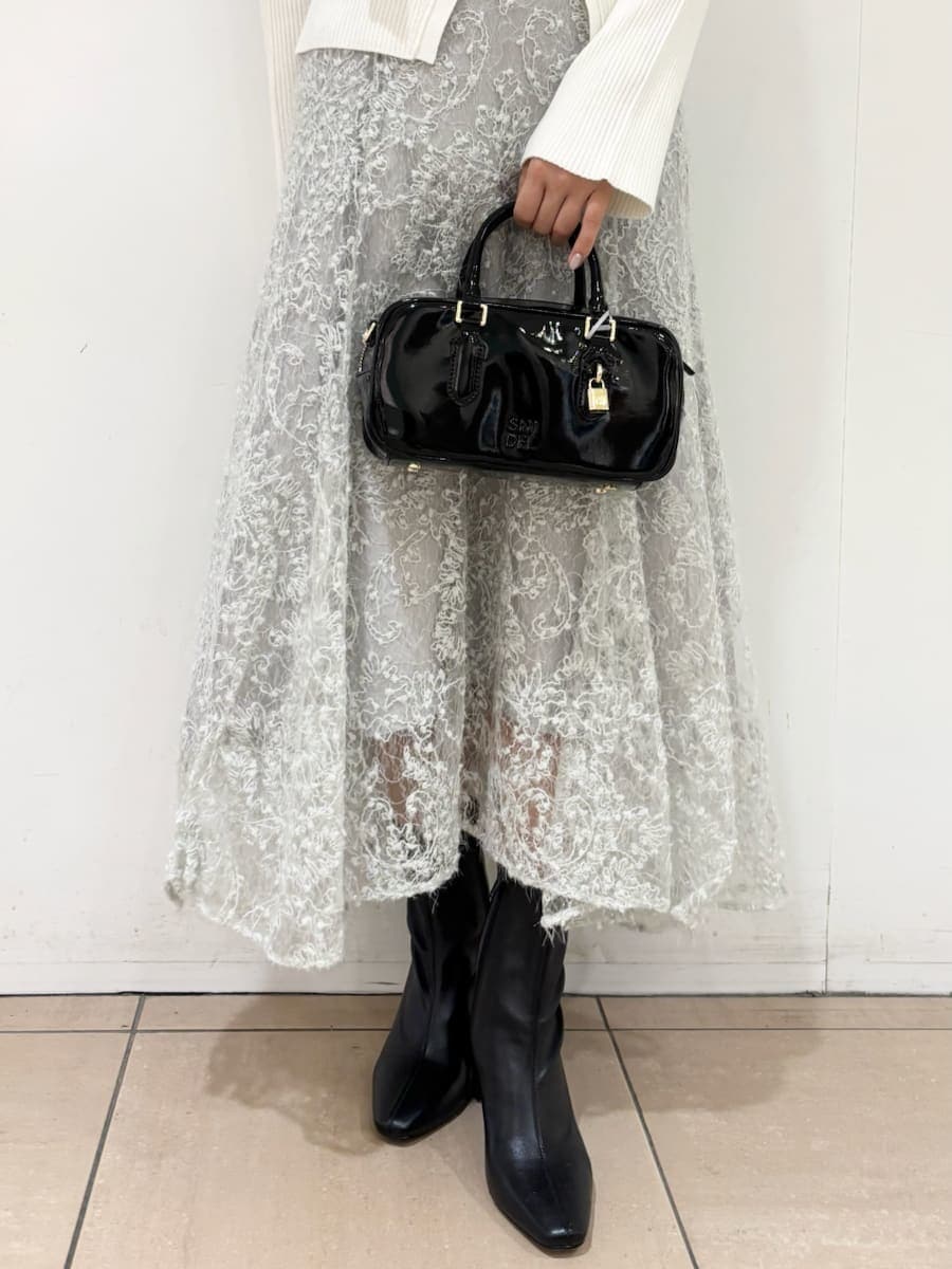 ホワイト系のニット/セーター、グリーン系のスカート、ブラック系のブーツを着用したレディースの秋コーディネートの5枚目の写真