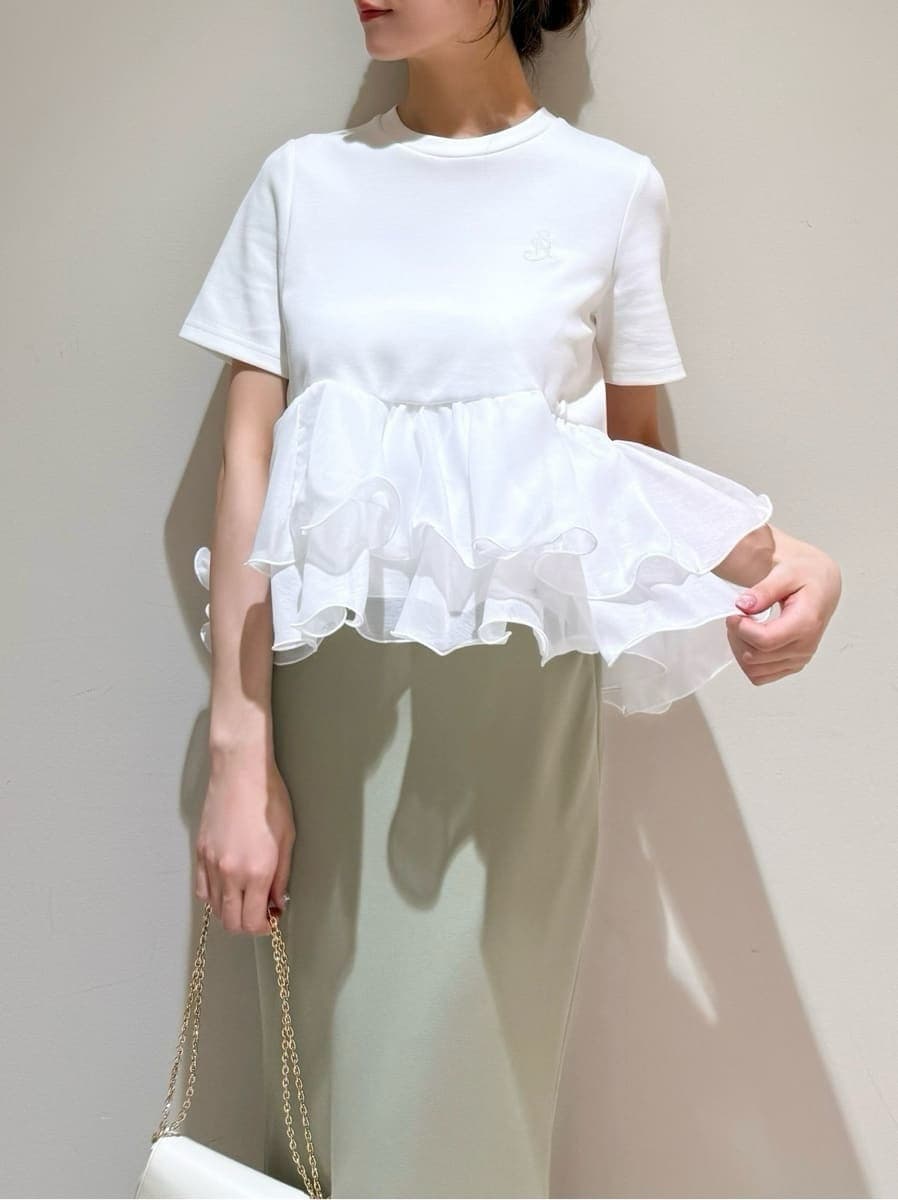 グリーン系のスカート、ホワイト系のTシャツ/カットソー、ホワイト系のショルダーバッグを着用したレディースの春コーディネートの3枚目の写真