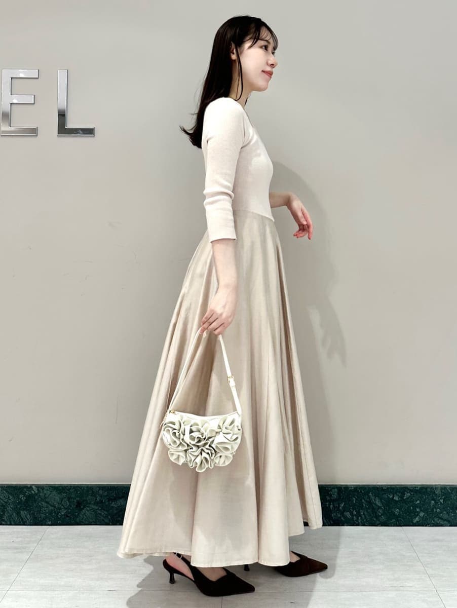 ブラウン系のパンプス、ホワイト系のハンドバッグを着用したレディースの冬コーディネートの4枚目の写真