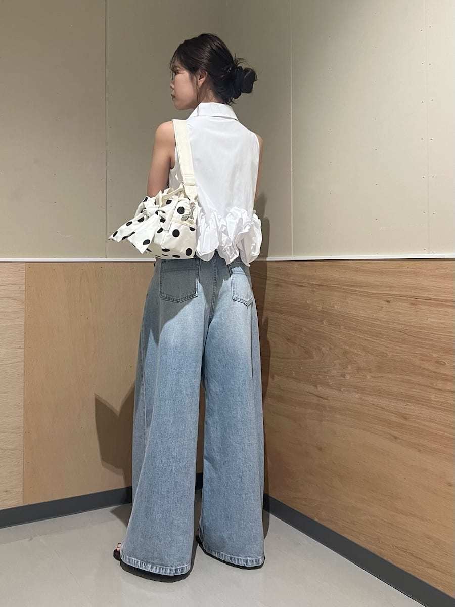ブルー系のデニムパンツ、ホワイト系のシャツ/ブラウス、ホワイト系のショルダーバッグを着用したレディースの夏コーディネートの3枚目の写真