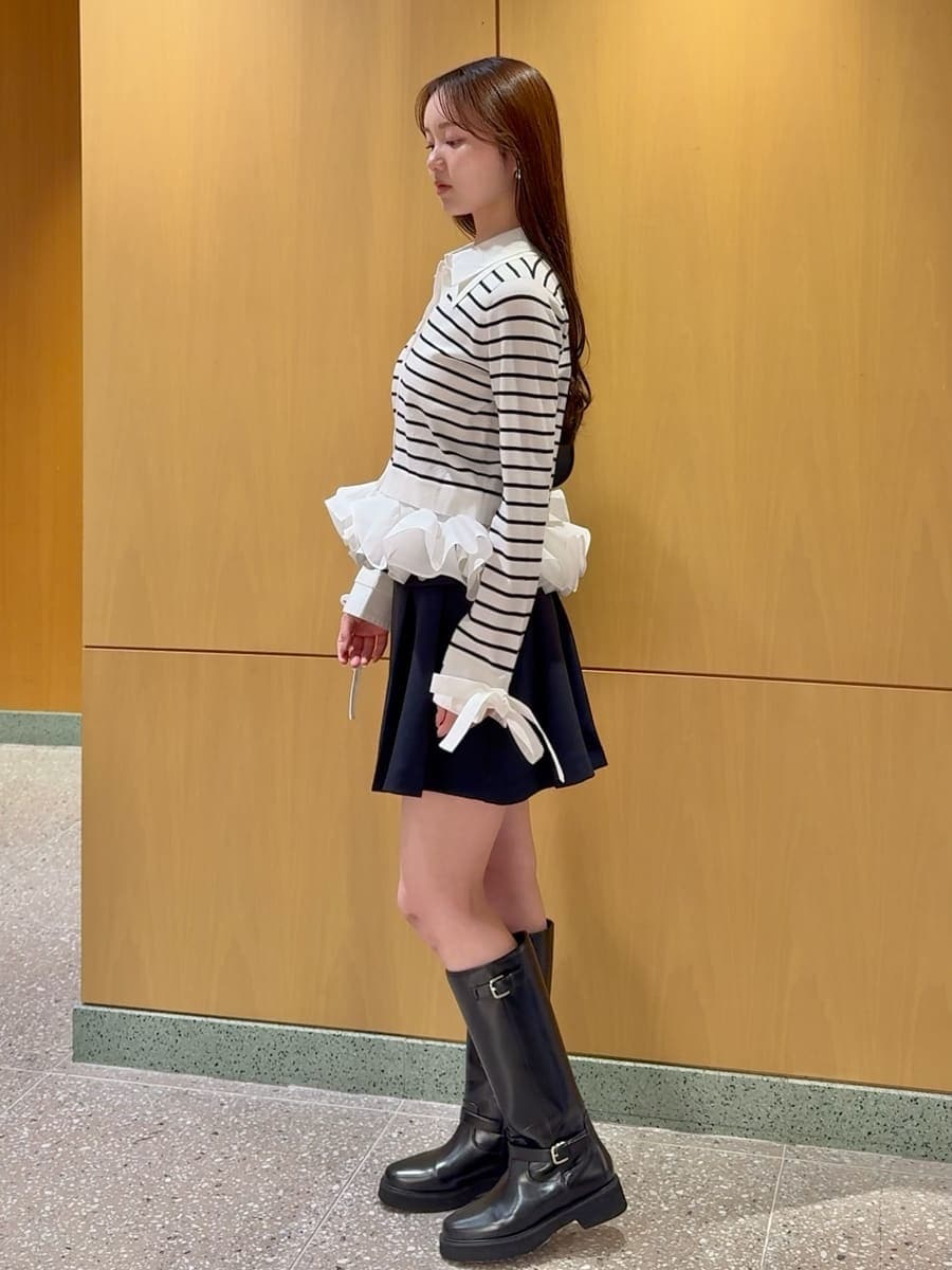 ブラック系のブーツ、ブルー系のスカート、その他のニット/セーターを着用したレディースの冬コーディネートの3枚目の写真