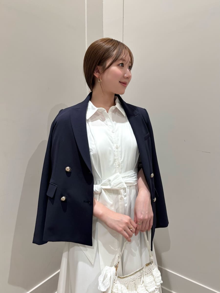 ブルー系のテーラードジャケット、ホワイト系のワンピース、ブラウン系のパンプスを着用したレディースの冬コーディネートの5枚目の写真