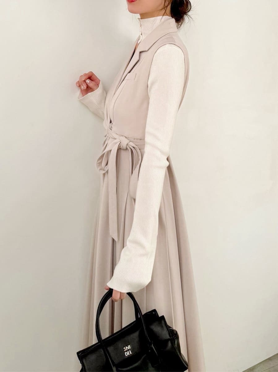 ブラック系のブーツ、ベージュ系のワンピース、ホワイト系のニット/セーターを着用したレディースの秋コーディネートの4枚目の写真