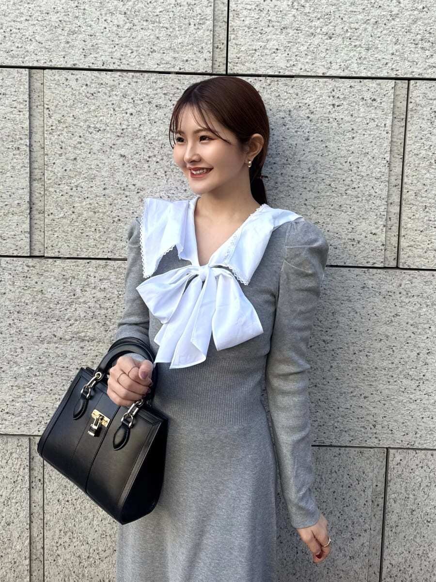 ブラック系のハンドバッグ、グレー系のワンピースを着用したレディースの冬コーディネートの2枚目の写真