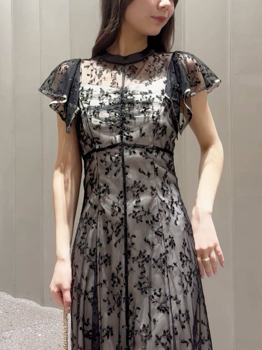 ブラック系のパンプス、ブラック系のショルダーバッグ、ブラック系のドレスを着用したレディースの春コーディネートの4枚目の写真