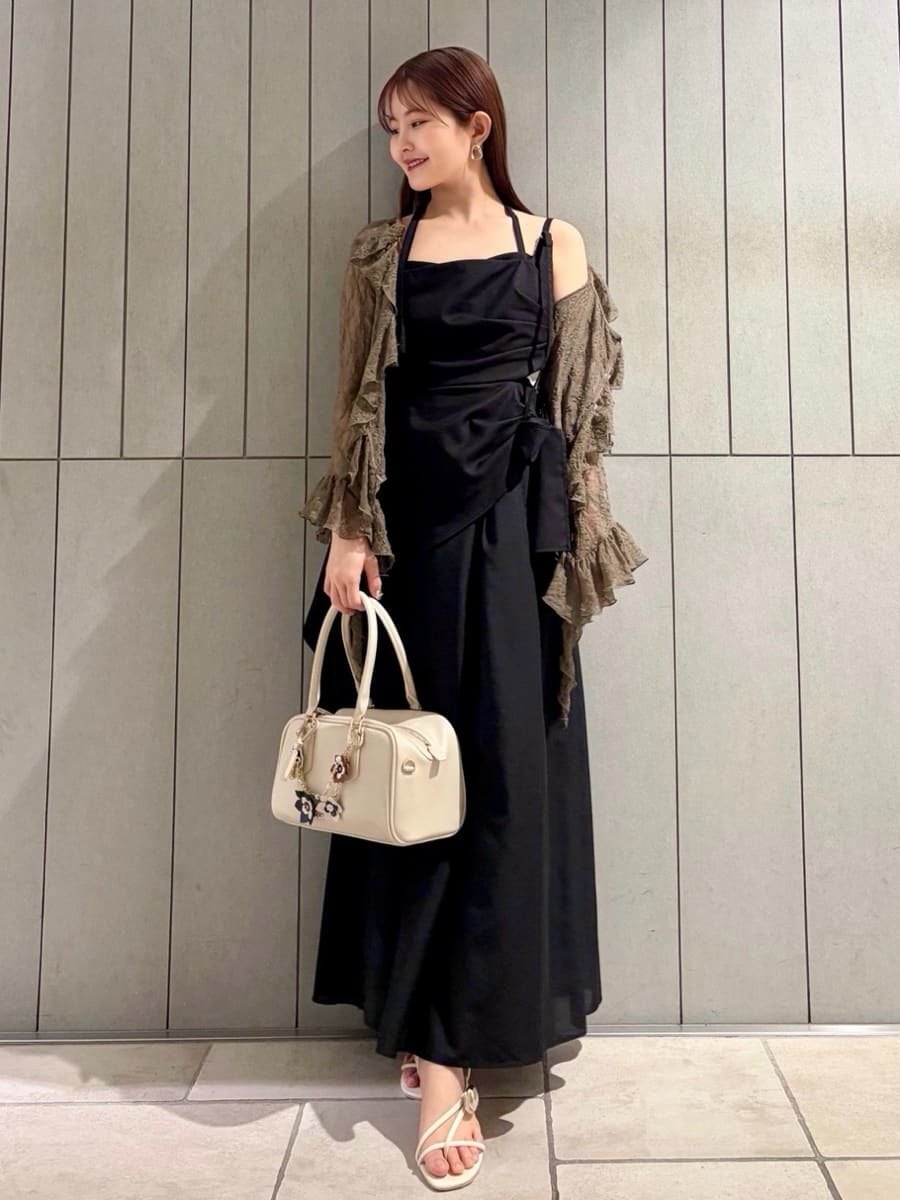 ブラック系のワンピース、グリーン系のTシャツ/カットソー、ホワイト系のボストンバッグを着用したレディースの春コーディネートの3枚目の写真