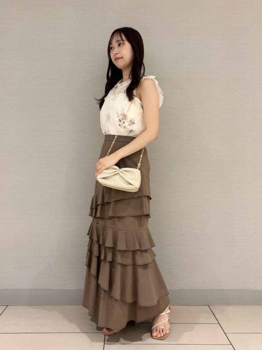 ベージュ系のスカート、ホワイト系のシャツ/ブラウス、その他のサンダルを着用したレディースの夏コーディネートの2枚目の写真