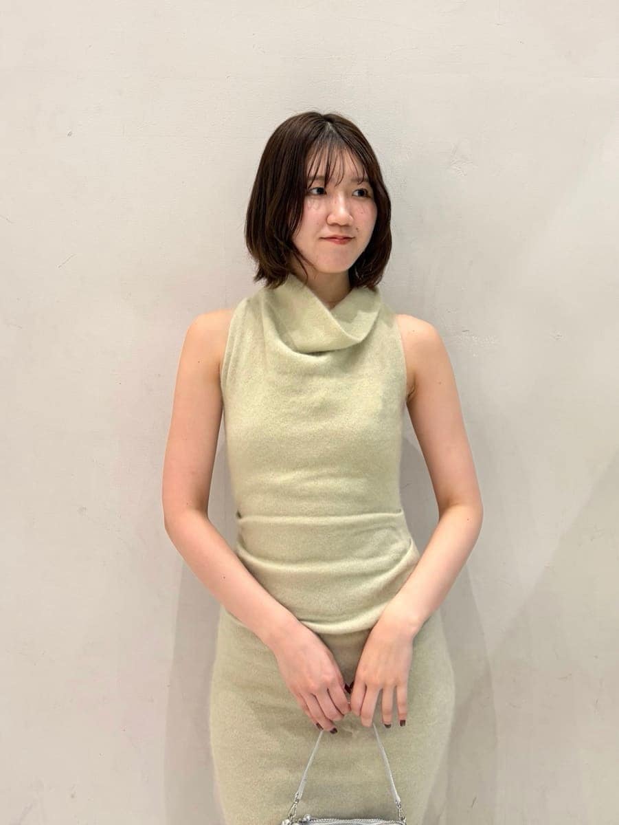 ベージュ系のキャミソール、グリーン系のチェスターコート、グリーン系のワンピースを着用したレディースの冬コーディネートの5枚目の写真