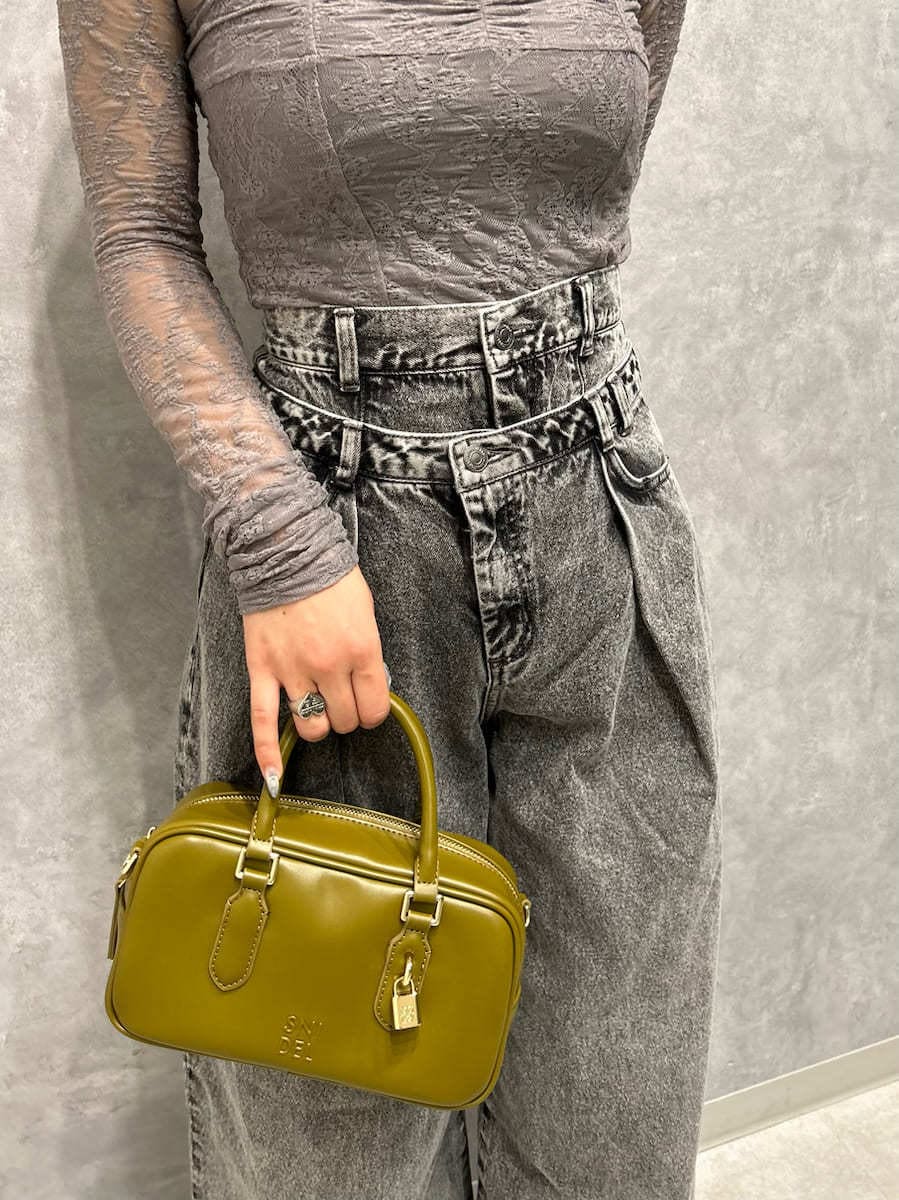 グレー系のTシャツ/カットソー、グレー系のデニムパンツ、グリーン系のボストンバッグを着用したレディースの秋コーディネートの7枚目の写真