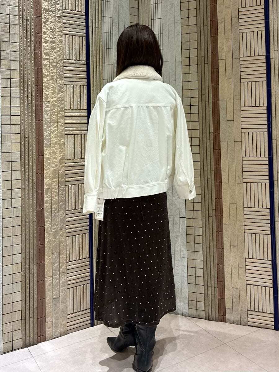 ブラック系のブーツ、ホワイト系のブルゾン、その他のワンピースを着用したレディースの冬コーディネートの3枚目の写真