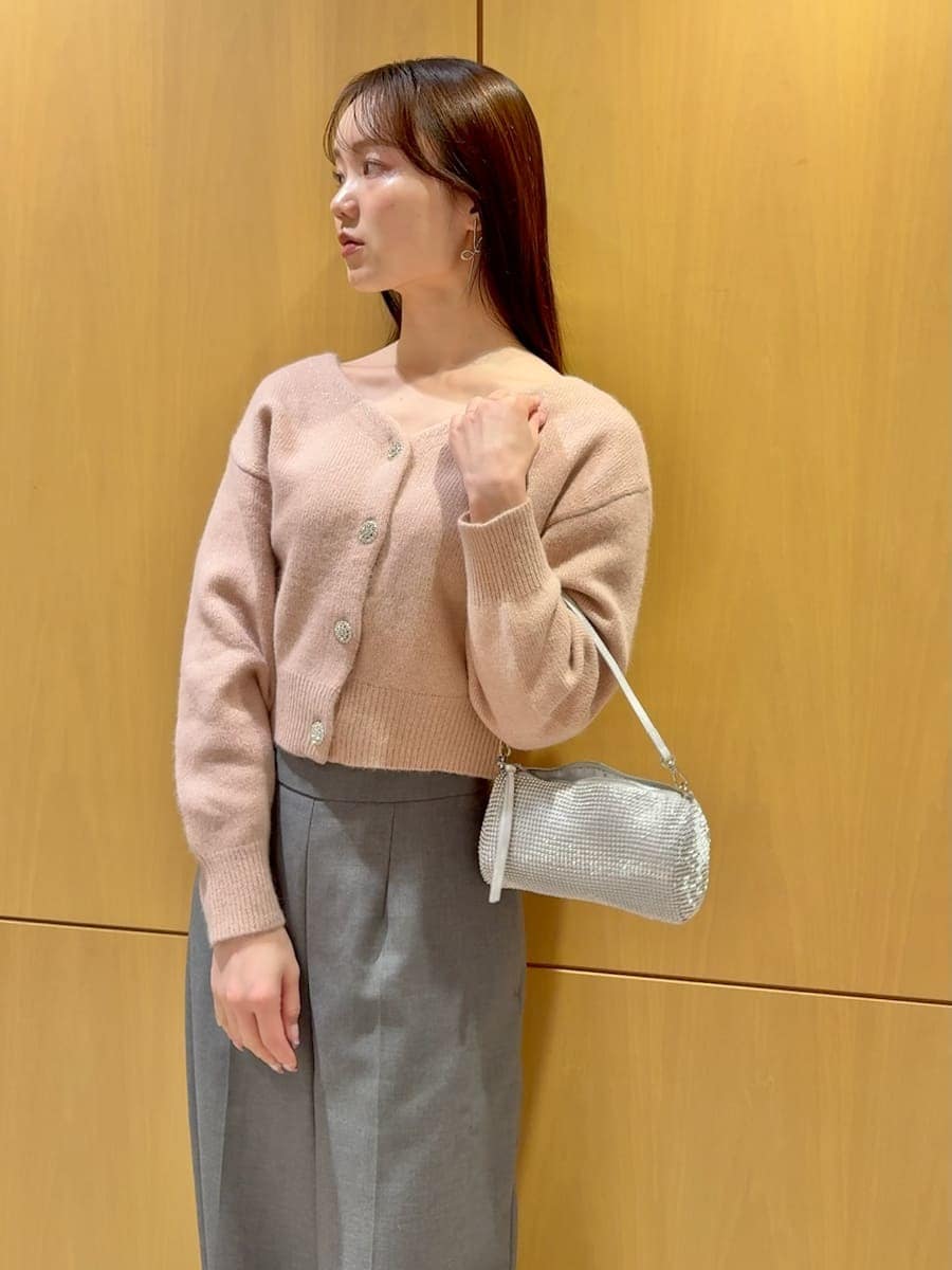 グレー系のスラックス、ピンク系のカーディガン/ボレロを着用したレディースの冬コーディネートの5枚目の写真