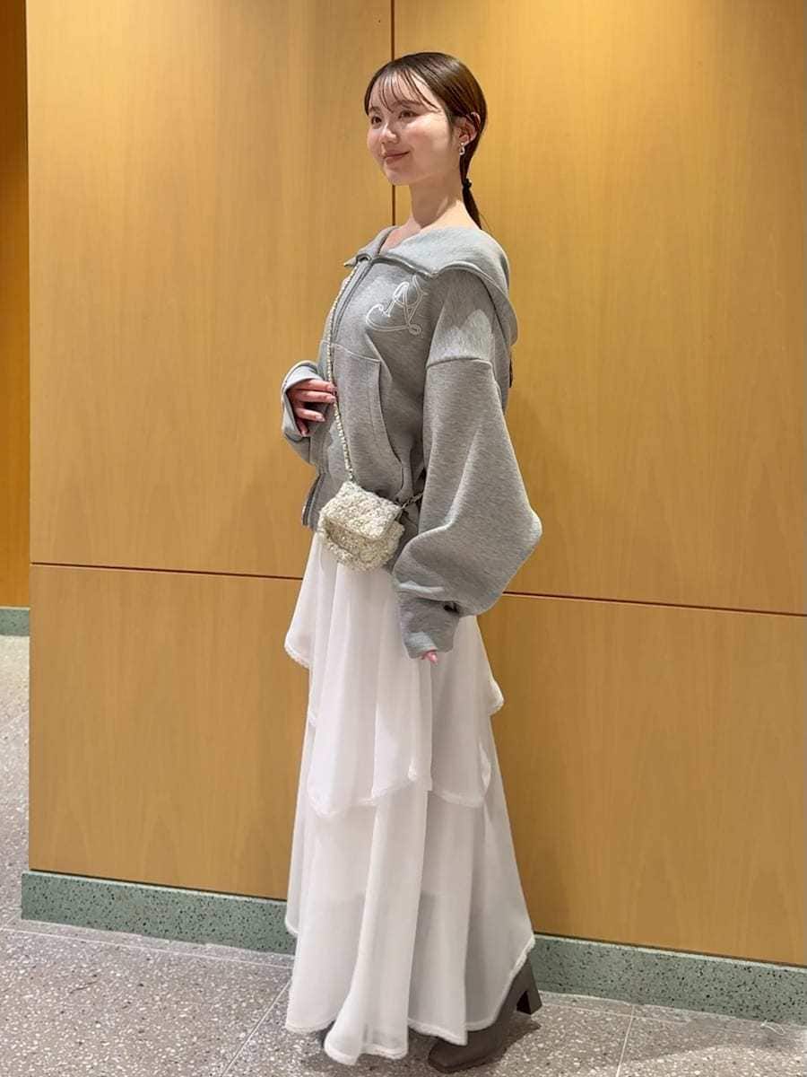 ホワイト系のショルダーバッグ、ホワイト系のスカート、グレー系のパーカーを着用したレディースの冬コーディネートの2枚目の写真