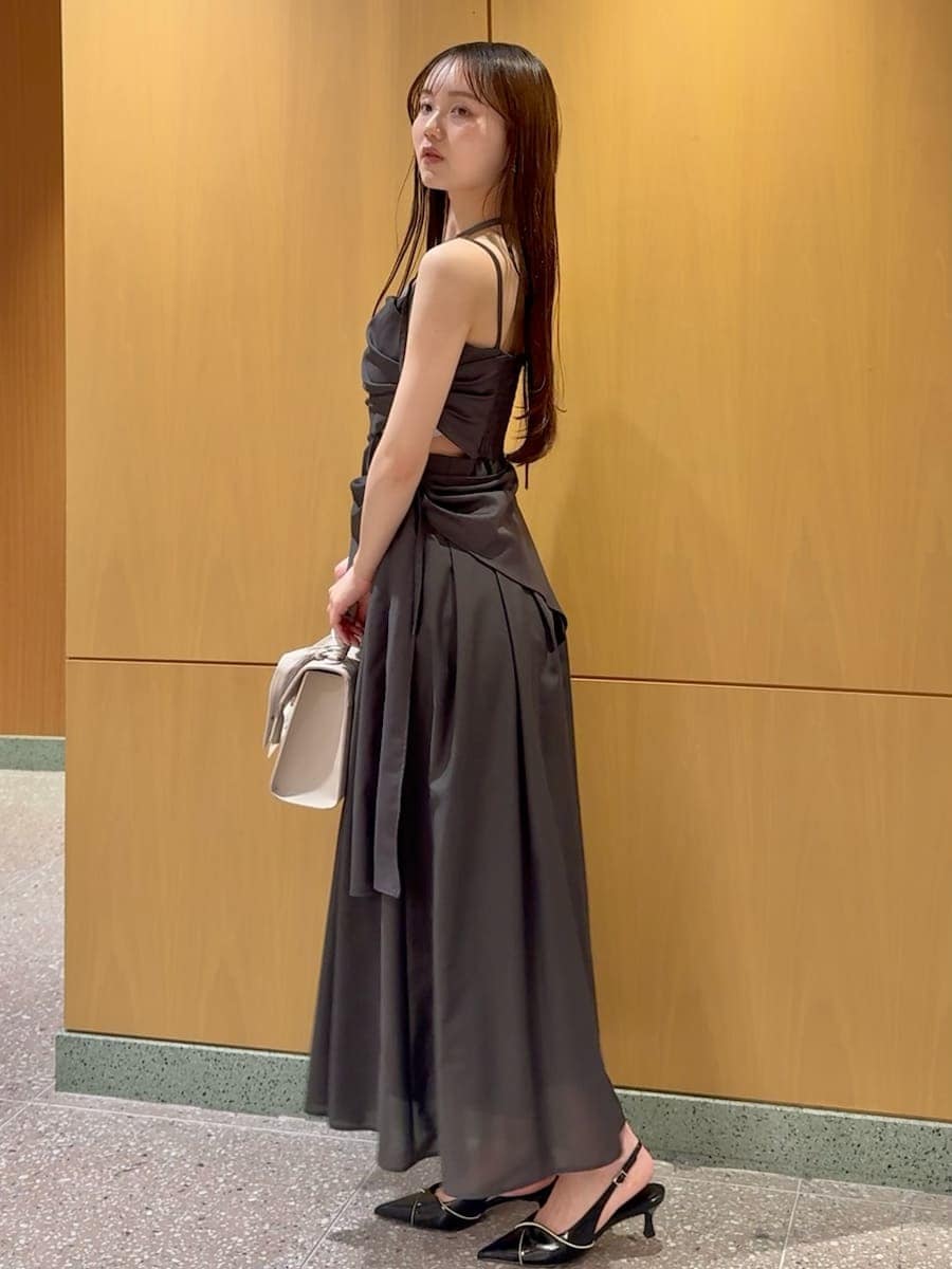 グレー系のワンピース、ブラック系のパンプス、ベージュ系のハンドバッグを着用したレディースの春コーディネートの2枚目の写真