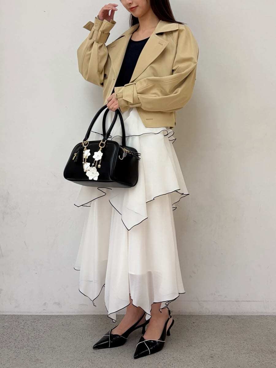 ベージュ系のトレンチコート、ブルー系のワンピース、ブラック系のパンプスを着用したレディースの冬コーディネートの3枚目の写真