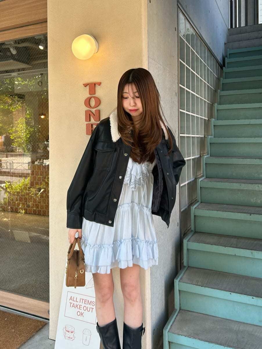 イエロー系のボストンバッグ、ブラック系のブルゾン、ブルー系のその他トップスを着用したレディースの冬コーディネートの5枚目の写真