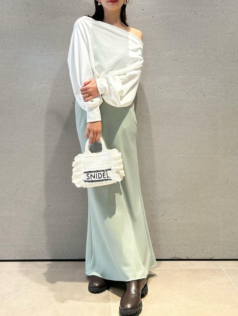 グリーン系のスカート、ホワイト系のスウェット、ホワイト系のショルダーバッグを着用したレディースの春コーディネートの6枚目の写真