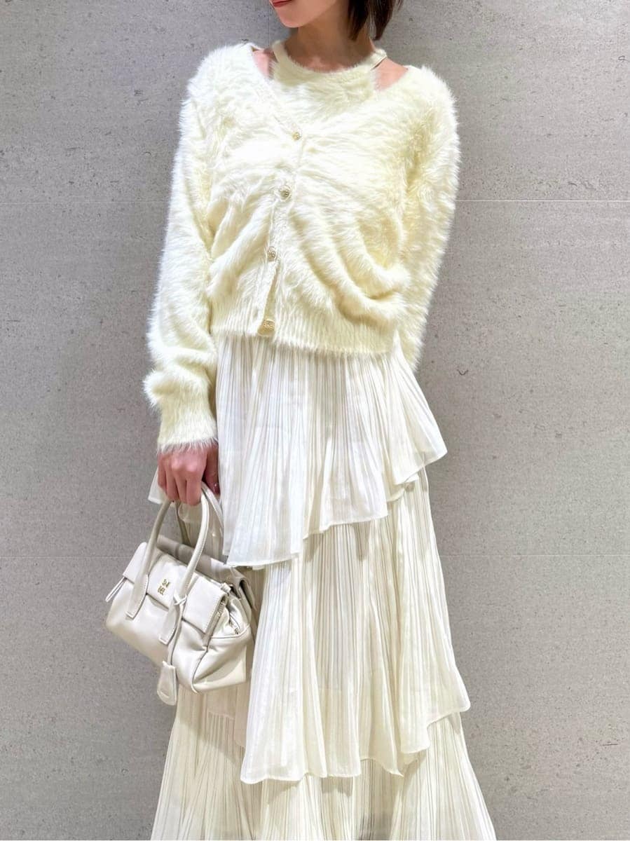 ブラウン系のブーツ、ホワイト系のスカート、イエロー系のニット/セーターを着用したレディースの秋コーディネートの3枚目の写真