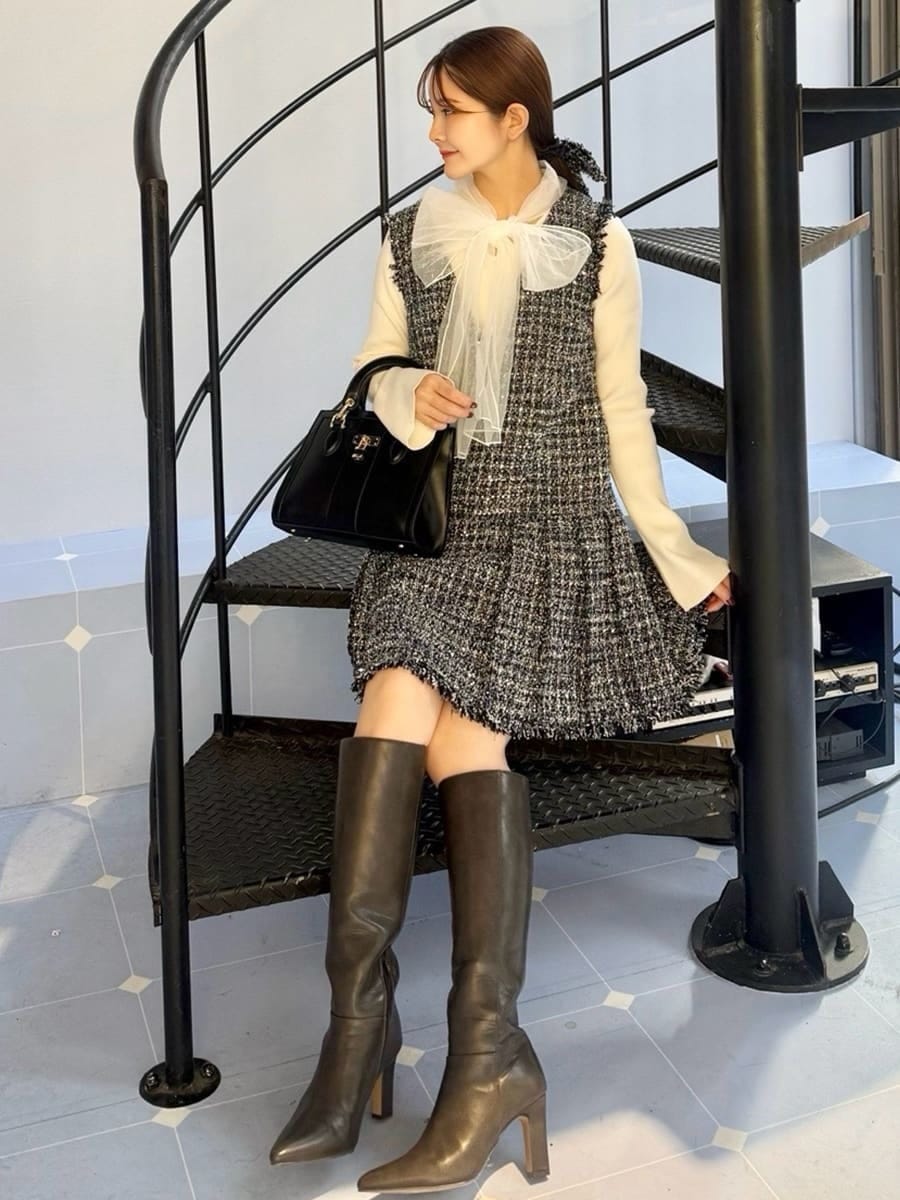 グレー系のブーツ、ブルー系のワンピース、ブラック系のハンドバッグを着用したレディースの冬コーディネートの5枚目の写真