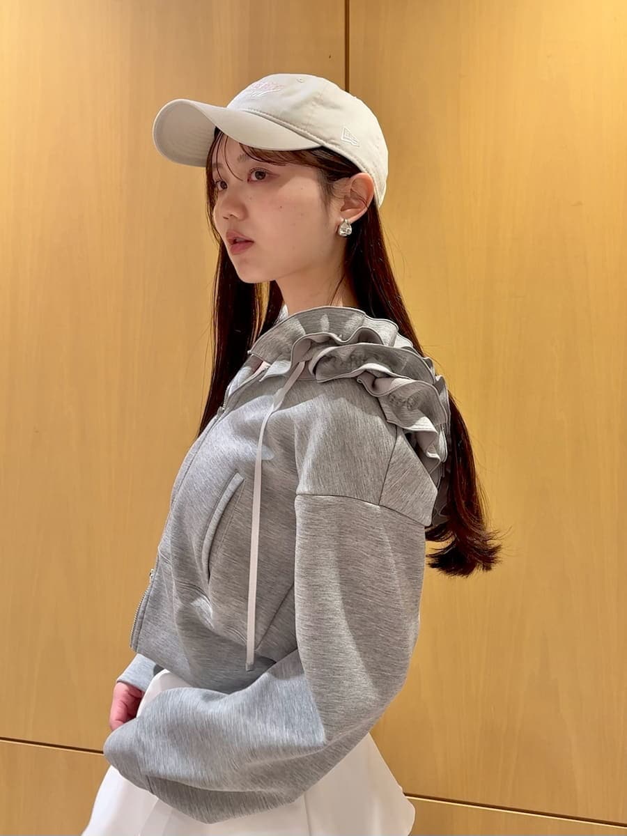 イエロー系のワンピース、グレー系のパーカー、シルバー系のピアス（両耳用）を着用したレディースの冬コーディネートの5枚目の写真