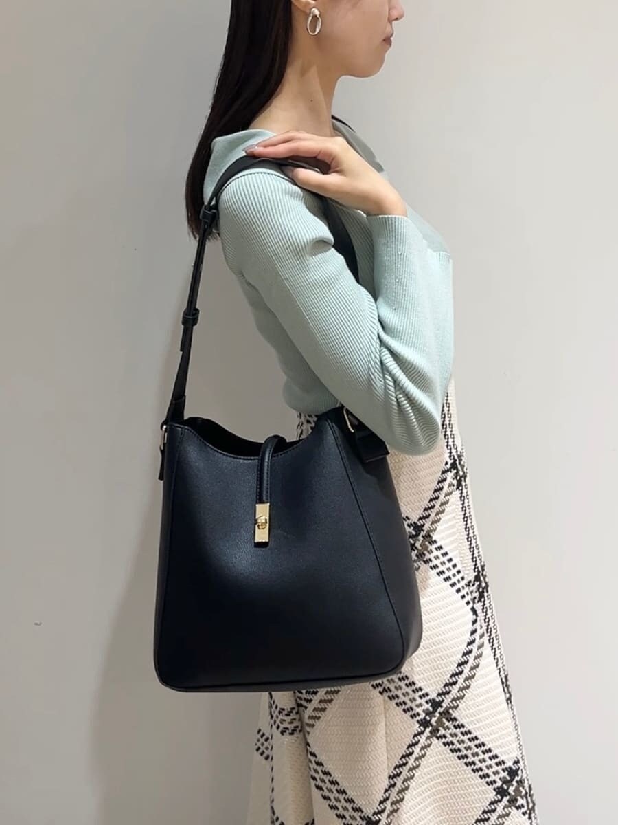 グリーン系のニット/セーター、ホワイト系のスカート、ブラック系のブーツを着用したレディースの秋コーディネートの3枚目の写真