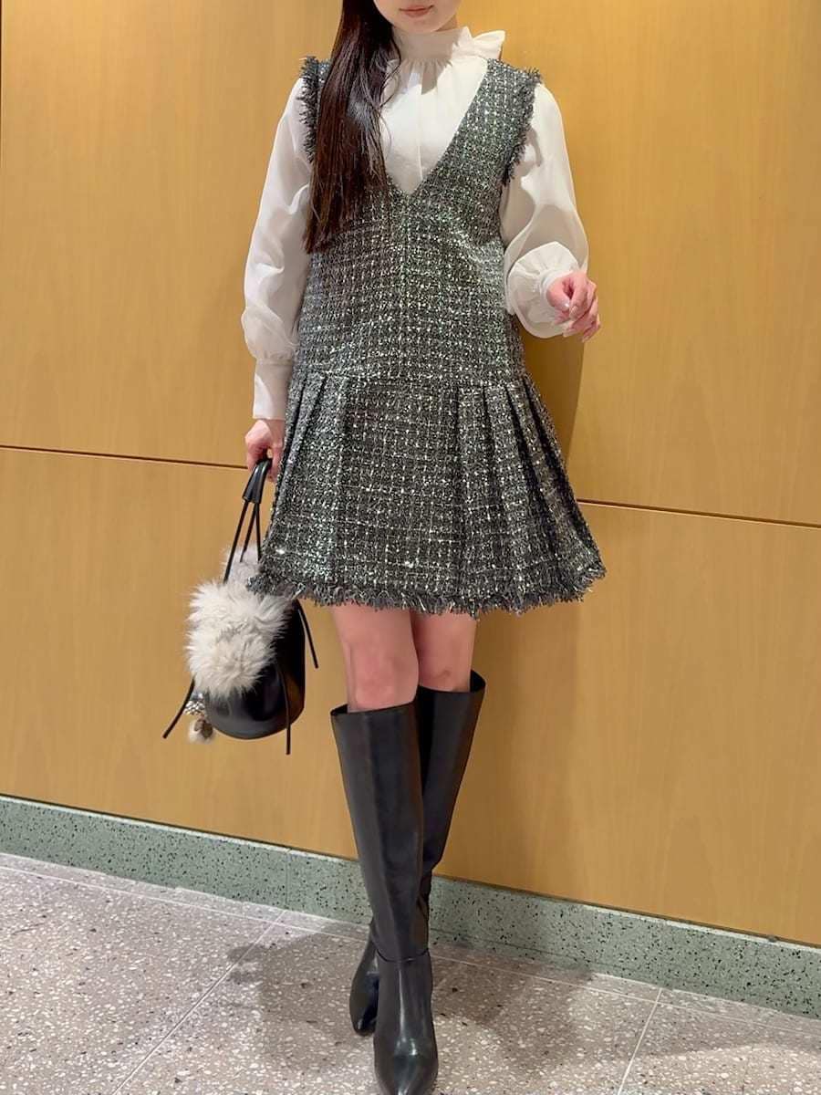 ブラック系のブーツ、グレー系のワンピース、ブラック系のハンドバッグを着用したレディースの冬コーディネートの7枚目の写真