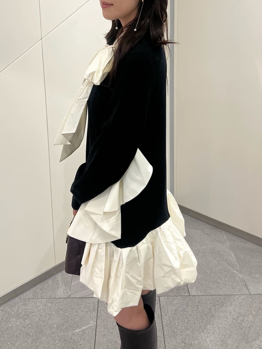 ブラック系のワンピース、ブラウン系のブーツ、レッド系のショルダーバッグを着用したレディースの秋コーディネートの7枚目の写真