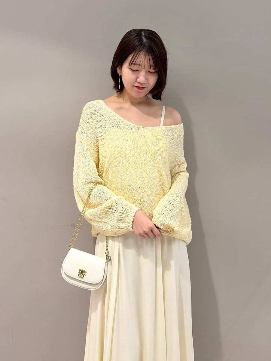 イエロー系のワンピース、ホワイト系のショルダーバッグ、シルバー系のスニーカーを着用したレディースの春コーディネートの4枚目の写真