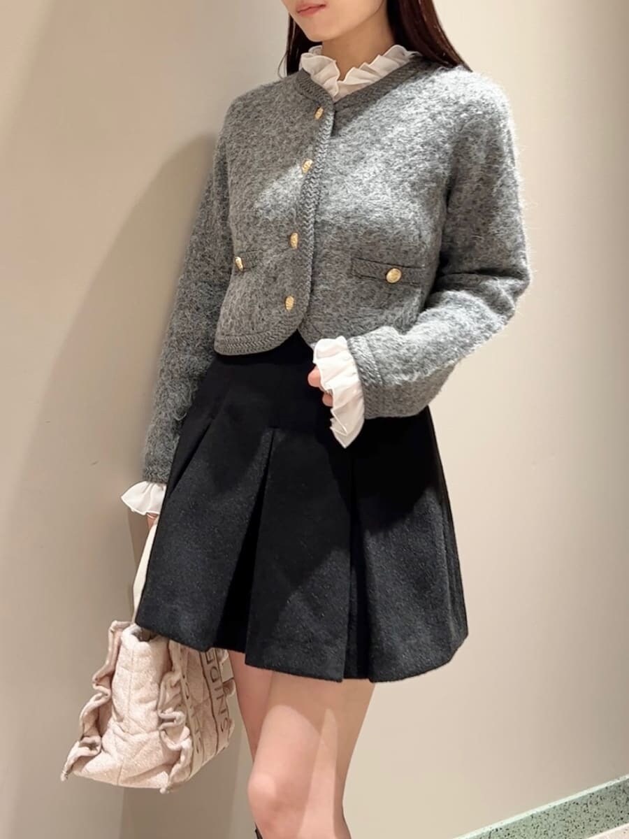 グレー系のノーカラージャケット、ブラック系のスカート、ピンク系のハンドバッグを着用したレディースの秋コーディネートの7枚目の写真