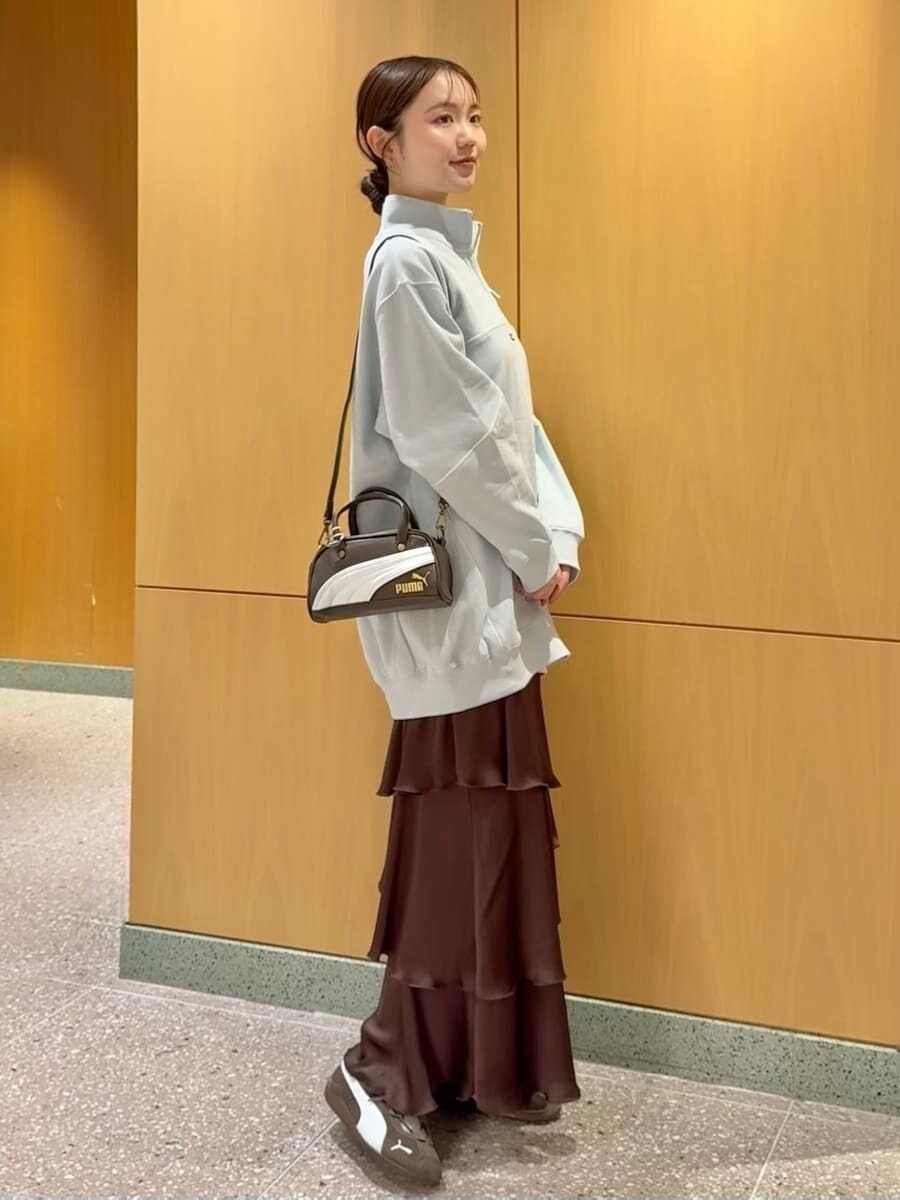 ブラウン系のスカートを着用したレディースの秋コーディネートの2枚目の写真