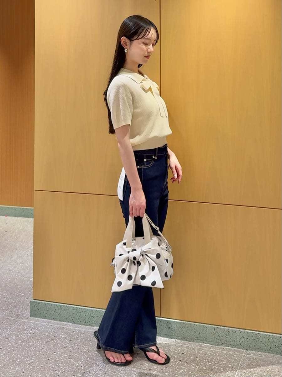 ブルー系のデニムパンツ、ホワイト系のショルダーバッグを着用したレディースの春コーディネートの2枚目の写真