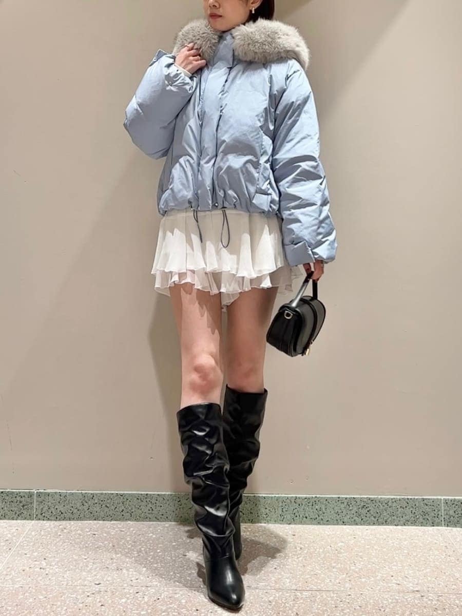 ブラック系のハンドバッグ、ブルー系のダウンジャケット/コート、ホワイト系のその他パンツを着用したレディースの秋コーディネートの4枚目の写真