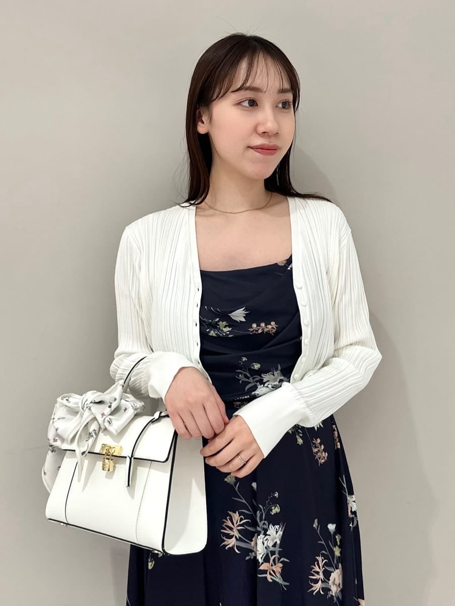 ホワイト系のカーディガン/ボレロ、ブルー系のワンピース、ブラック系のパンプスを着用したレディースの冬コーディネートの2枚目の写真