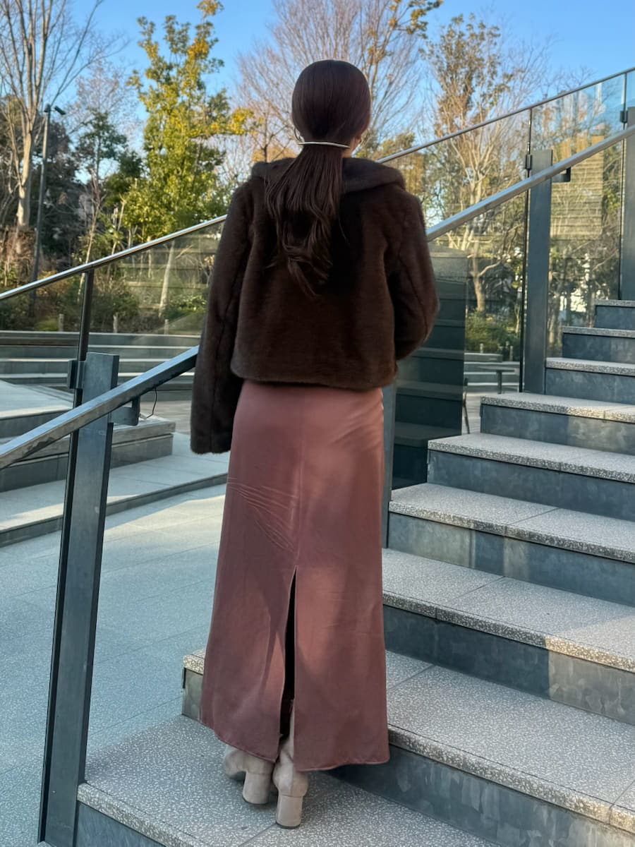 ブラウン系のステンカラーコートを着用したレディースの冬コーディネートの3枚目の写真