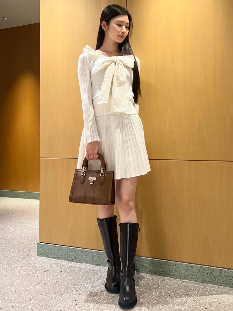 ブラック系のブーツ、ホワイト系のワンピース、ブラウン系のハンドバッグを着用したレディースの冬コーディネートの4枚目の写真