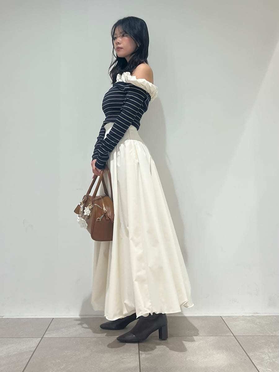 ブラウン系のブーツ、ホワイト系のスカート、その他のニット/セーターを着用したレディースの冬コーディネートの2枚目の写真